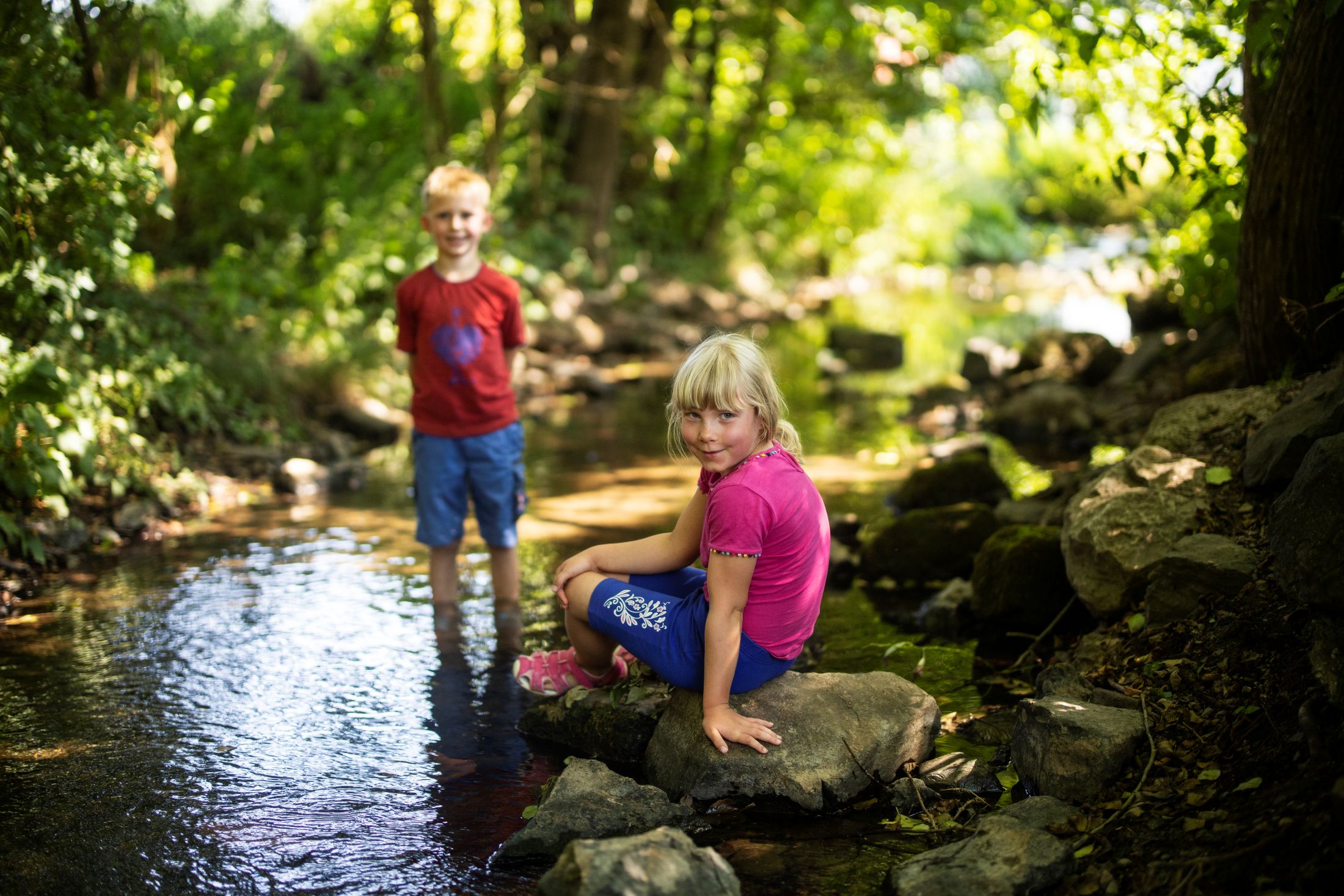 Kinder planschen am Bach im Grünen in Willingen Zwei Kinder spielen im Bach bei einem Familienurlaub in Willingen