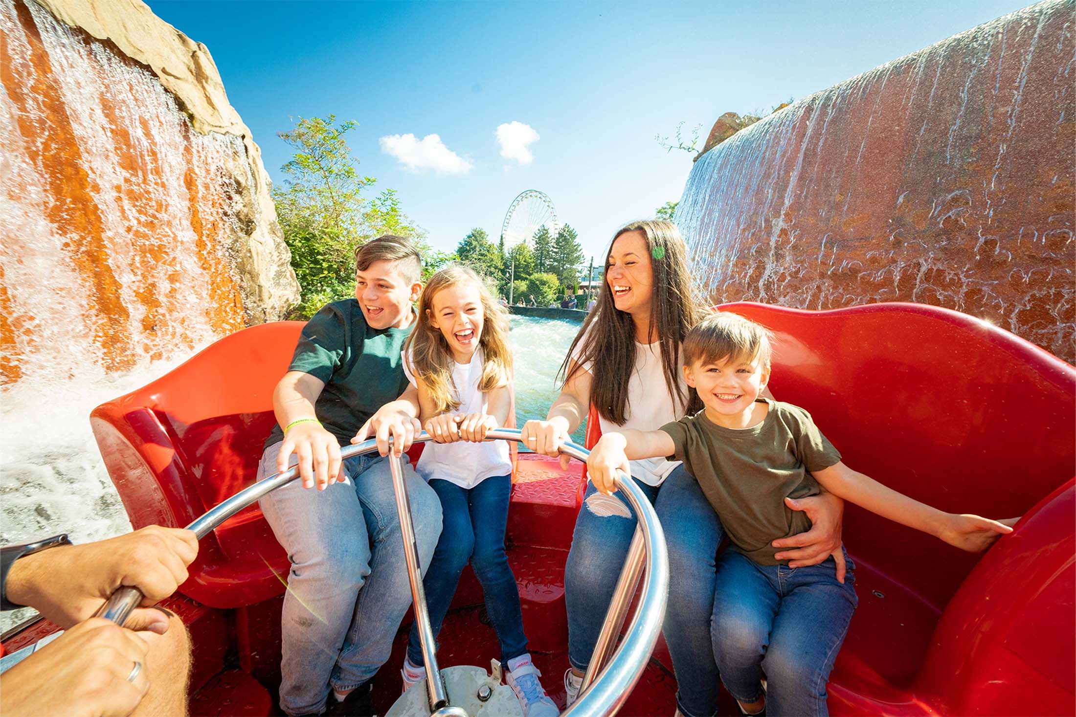 Fröhliche Familie auf der Wasserbahn Los Rapidos im FORT FUN Kinder und Eltern lachen gemeinsam auf der Wasserattraktion im Freizeitpark FORT FUN