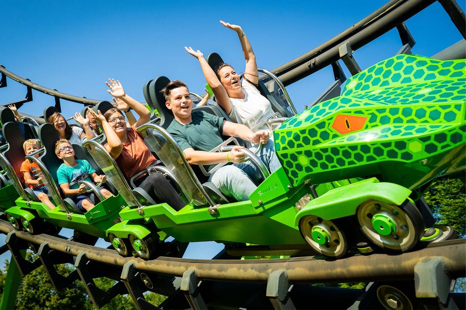 Familienachterbahn im FORT FUN Abenteuerland mit lachenden Fahrgästen Eltern und Kinder genießen gemeinsam eine Achterbahnfahrt im FORT FUN Freizeitpark