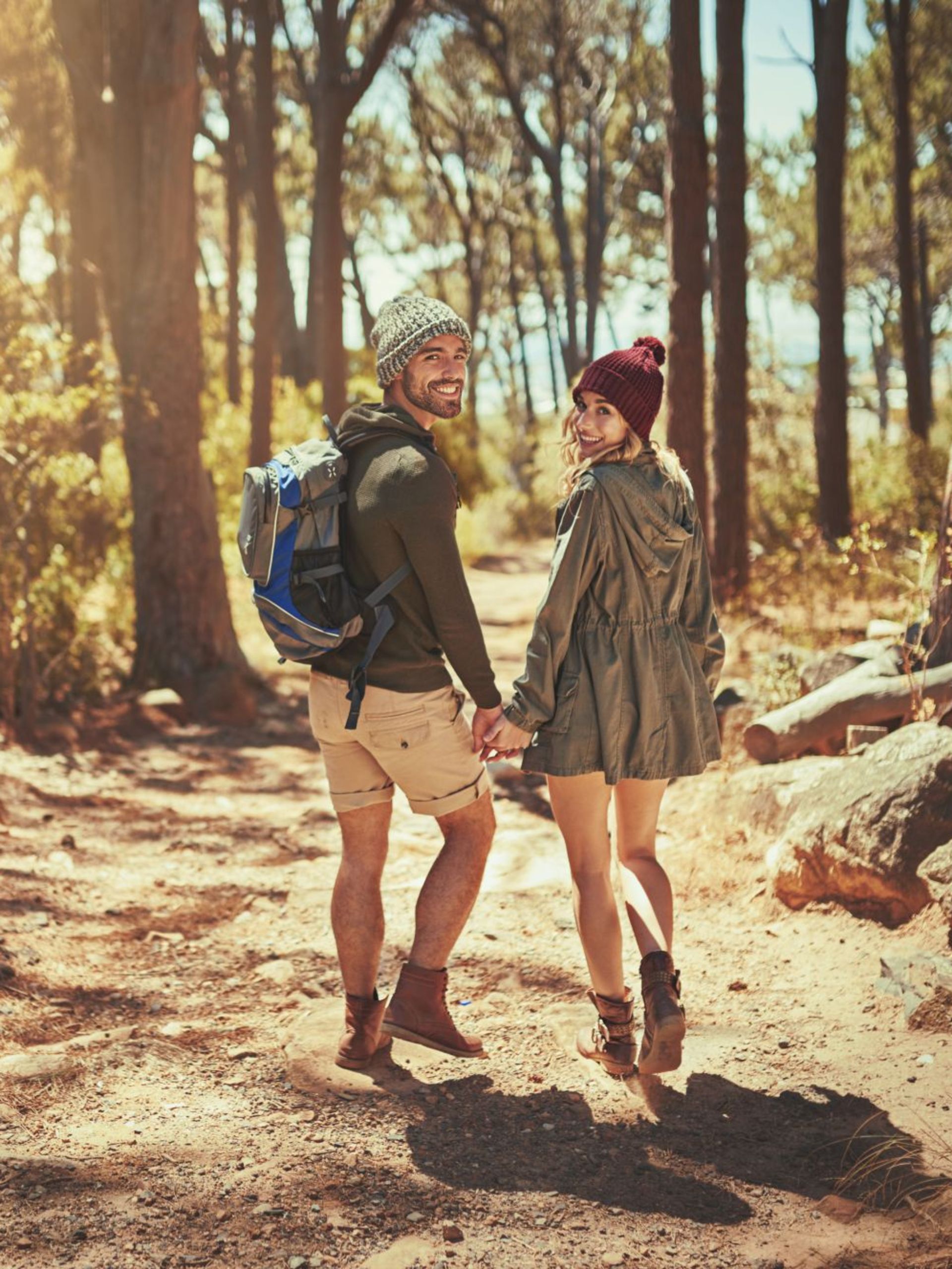 Paar beim Sommerurlaub in Willingen beim Wandern durch den Wald Fröhliches Paar wandert Hand in Hand durch den sonnigen Wald im Sauerland – Sommerurlaub im Hotel Eimberg